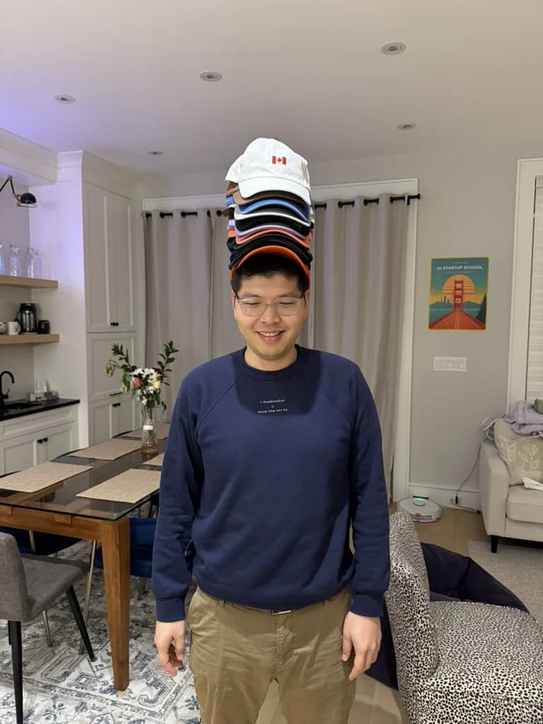 Jerry Jiang balancing a stack of caps on his head.